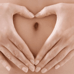 Heart hand over belly